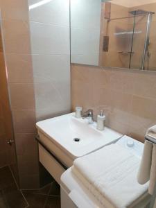 a bathroom with a white sink and a shower at Apartments and Rooms Tomas in Podstrana