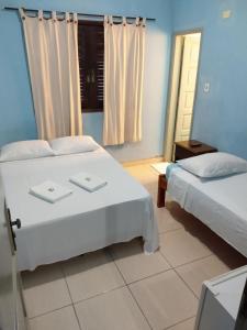 a bedroom with two beds and a window at Hotel Paulista in São Vicente