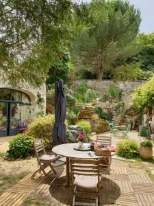 eine Terrasse mit einem Tisch und Stühlen im Garten in der Unterkunft Gîte la comète in Chinon
