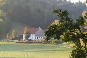 a white barn in the middle of a field at Märzenburghof in Kaufbeuren