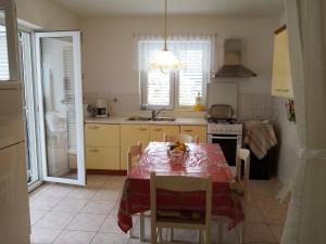 a kitchen with a table with a red table cloth on it at Kuća za odmor Mendez in Labin