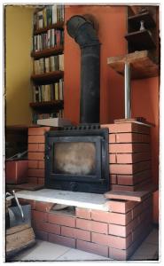 a brick fireplace with a stove in a library at Rancho Relaxo Czartoria in Miączyn