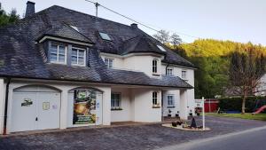 a white house with a black roof at Zimmerappartement "Rose" - Ferienwohnungen Wagner & Gaul in Falkenauel