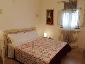 - une chambre avec un lit, une couverture et une fenêtre dans l'établissement B&B Giovannarolla Green House, à Ostuni