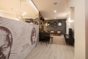 a living room with a wall with a picture of a man at The ICONS Lisbon Central Hotel in Lisbon
