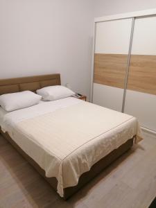 a bedroom with a large bed with white sheets at Apartments and Rooms Tomas in Podstrana