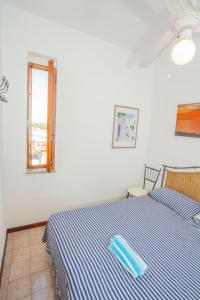 a bedroom with a blue and white bed with a window at SeaBreeze Baia Verde in Baia Verde