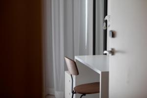a white chair sitting in front of a window at The Icons by TRIUS Hotels in Lisbon