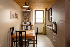 a kitchen with a wooden table and a table and chairs at PICCOLA VILLA nel Centro Storico in Arona