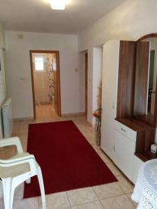 a living room with a red rug and a white refrigerator at Kuća za odmor Mendez in Labin