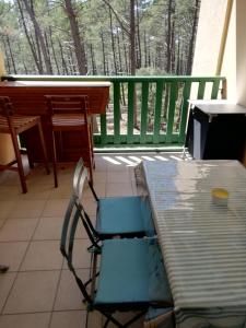 een stoel en een tafel op een veranda bij LES GRANDS PINS in Carcans