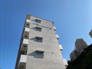 a tall building with a clock on the side of it at ホテルトーマス牧港ヴィラ in Urasoe