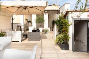 an outdoor patio with an umbrella and plants at Casa Minerva Al Pantheon in Rome