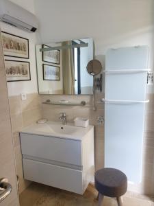 a bathroom with a sink and a refrigerator at Gîte la comète in Chinon