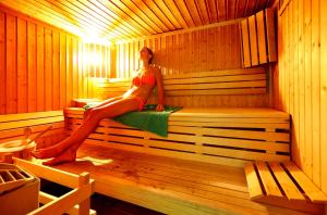 a woman is sitting in a sauna at Golden Residence Hotel in Funchal