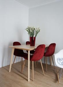 a table and chairs with a vase on top of it at Casa da Laurindinha in Ponte de Lima