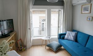 a living room with a blue couch and a window at Casa da Laurindinha in Ponte de Lima