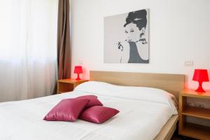Schlafzimmer mit einem weißen Bett und roten Kissen in der Unterkunft Isola Apartments in Mailand