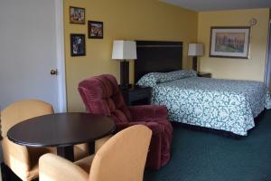 a hotel room with a bed and a table and chairs at The Cullars Inn in Lincolnton