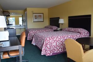 ein Hotelzimmer mit 2 Betten, einem Tisch und Stühlen in der Unterkunft The Cullars Inn in Lincolnton