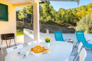 een witte tafel en stoelen op een patio met uitzicht bij ARADAS, Pampilhosa da Serra, Casa da Oliveira, Wifi, Ar Condicionado, Churrasqueira, Parqueamento, by IG in Unhais-o-Velho