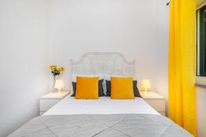 a bedroom with a white bed with yellow pillows at Casa da Oliveira, Aradas, Pampilhosa da Serra, Wifi, Ar Condicionado, Churrasqueira, Parqueamento, by IG in Unhais-o-Velho