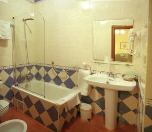 a bathroom with a sink and a tub and a toilet at Casa Manoli Luarca in Almuña