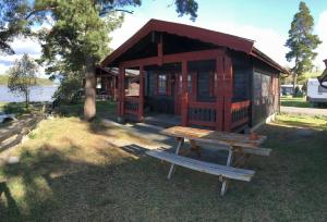 a wooden cabin with a picnic table in front of it at Odin Camping AS in Svensrud