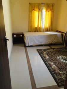 a bedroom with a bed and a window and a rug at PARADISE ESTATE PEACEFUL QUITE COMFORTABLE SECURED GATED WIFI pOOL in Old Yundum