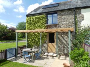 an extension to a cottage with a table and a patio at Devon Eco Lodges in Winkleigh