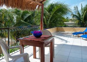 a table and chairs on a patio with a umbrella at Abbey Del Sol in Puerto Morelos