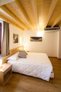 a bedroom with a white bed and a wooden ceiling at Hotel All'Arco in Trieste