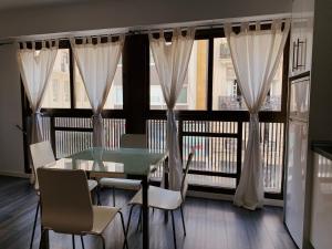 a dining room with a table and chairs and windows at Ayuntamiento Silence in Valencia