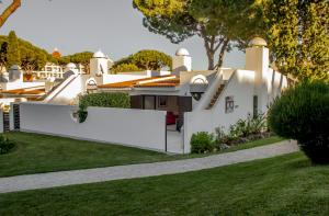 a white house with a fence and grass at BmyGuest - Vilamoura Golf Villa in Vilamoura