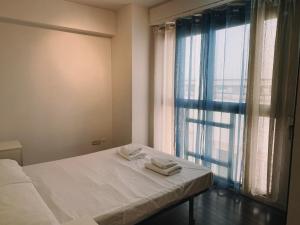 a bedroom with a bed and a window with towels on it at Ayuntamiento Silence in Valencia