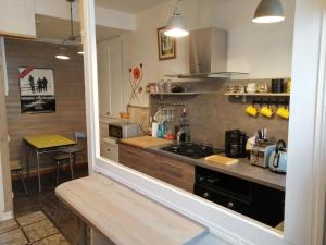 - une cuisine avec un comptoir et une cuisinière four supérieur dans l'établissement l'appart - appartement familial -classé 2 étoiles-, à Saint-Aignan