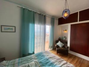 1 dormitorio con 1 cama, 1 silla y 1 ventana en Vistamar Vueltas en Valle Gran Rey