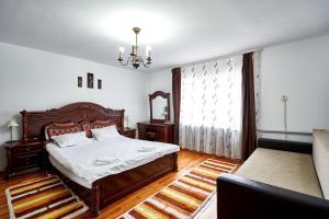 a bedroom with a bed and a couch at Camere de inchiriat ROMAN in Vişeu de Sus
