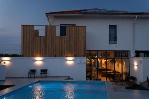 a villa with a swimming pool in front of a house at The Pines Boutique Villa - Vama Veche in Vama Veche