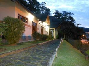 Pousada Pouso do Barão في دومينغوس مارتينز: منزل به شارع مرصوف بالحصى أمام منزل