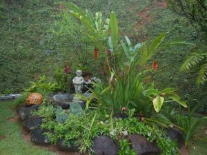 een tuin met een standbeeld en enkele planten bij Pousada Pouso do Barão in Domingos Martins
