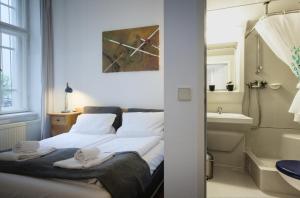 ein Schlafzimmer mit einem Bett und ein Badezimmer mit einem Waschbecken in der Unterkunft Altbauwohnung mit 3 Bädern (PB6) in Berlin