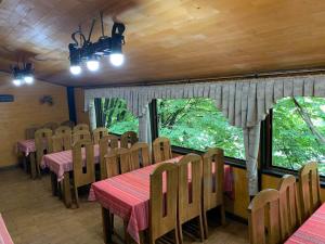 a dining room with tables and chairs and windows at Готель-ресторан Каміла in Polyana