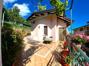 a small white house with a bench and flowers at Il ritrovo delle Volpi in Agerola