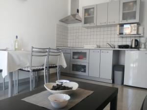 uma cozinha com uma mesa com uma taça de fruta em Lana Apartman em Medulin