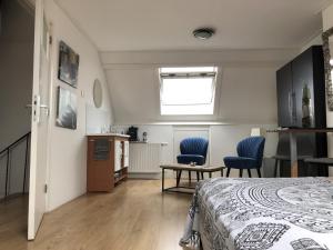 Un dormitorio con una cama y dos sillas azules. en PuraVida, en Westkapelle