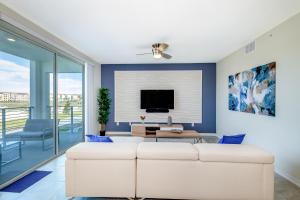 a living room with a white couch and a tv at (JA206) Storey Lake Condo 2/2, Free Waterpark in Kissimmee