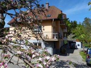 a house with a balcony and pink flowers at Locations Dupertuis Alsace in Le Hohwald