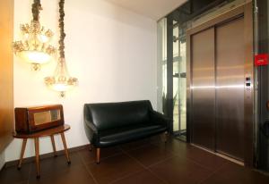 a black leather chair and a television in a room at Moderna in Coimbra