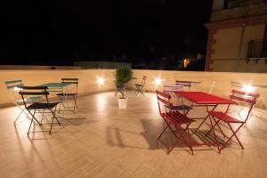 a group of tables and chairs on a patio at night at Residenza Le Zagare in Castellammare del Golfo